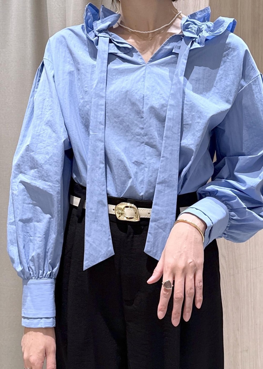 ホワイト系のショルダーバッグ、ブルー系のシャツ/ブラウス、ホワイト系のパンプスを着用したレディースの春コーディネートの7枚目の写真