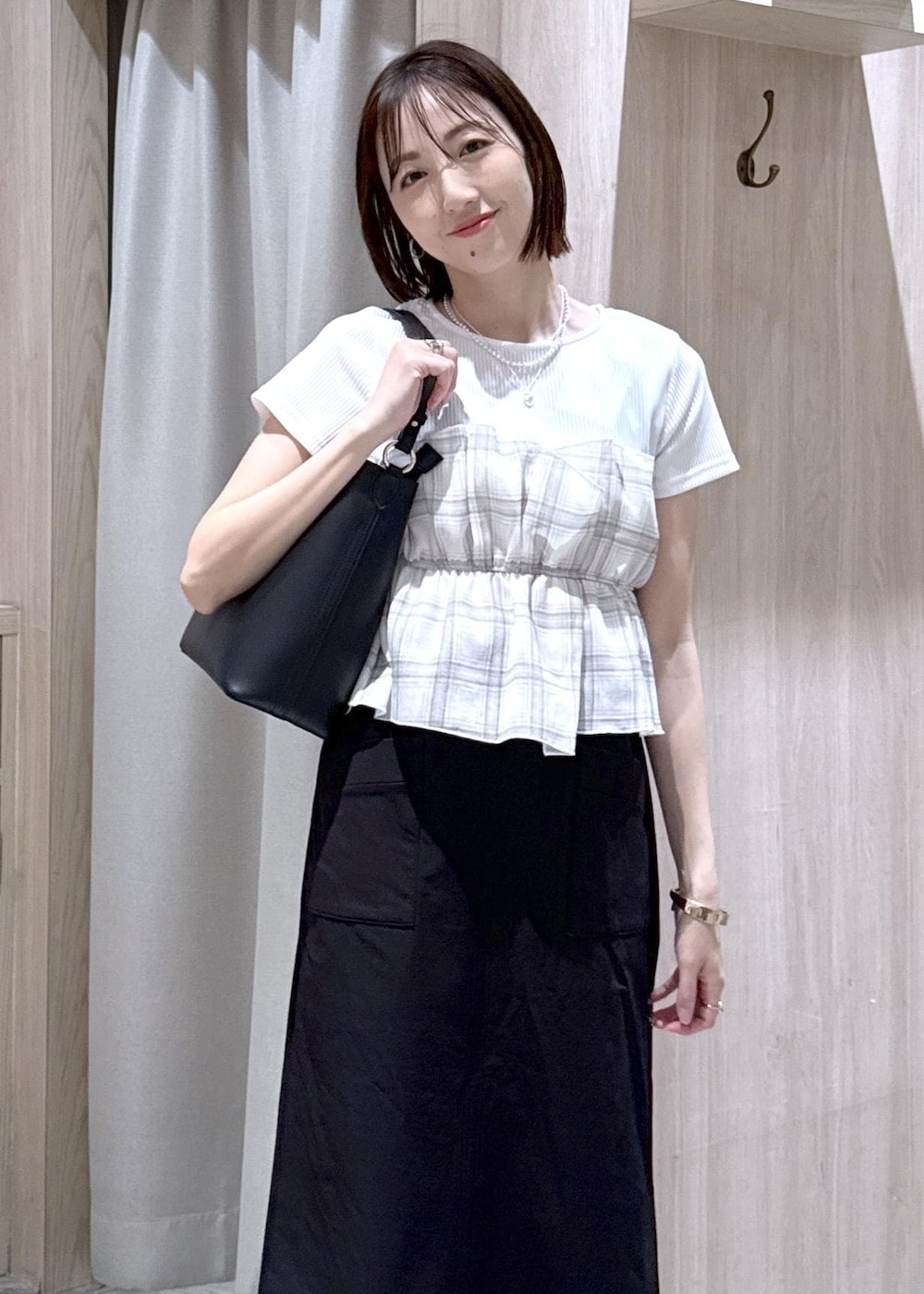 ブラック系のパンプス、ブラック系のスカート、ホワイト系のTシャツ/カットソーを着用したレディースの春コーディネートの3枚目の写真