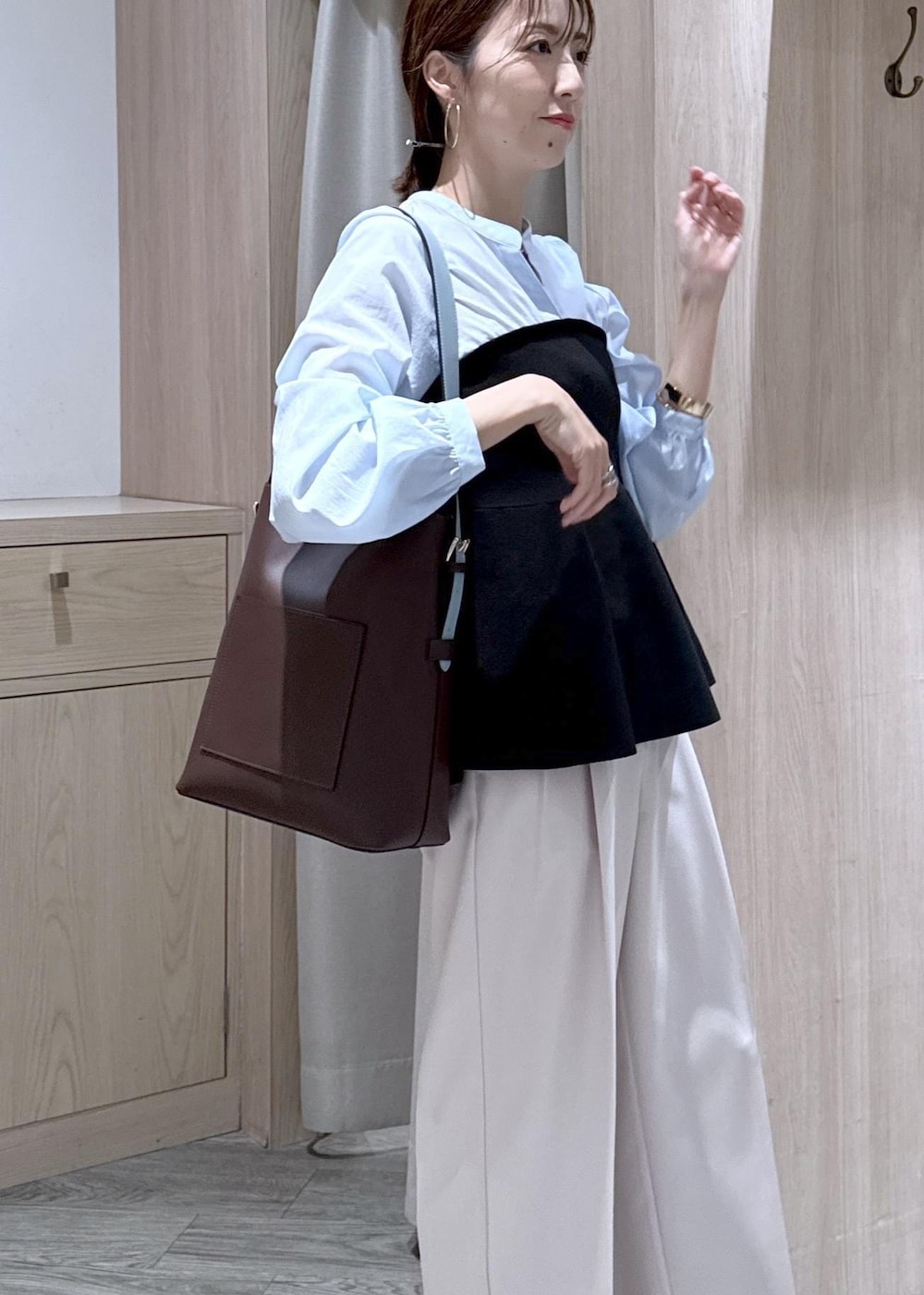 ブラウン系のトートバッグ、ベージュ系のその他パンツ、ブラック系のシャツ/ブラウスを着用したレディースの春コーディネートの3枚目の写真