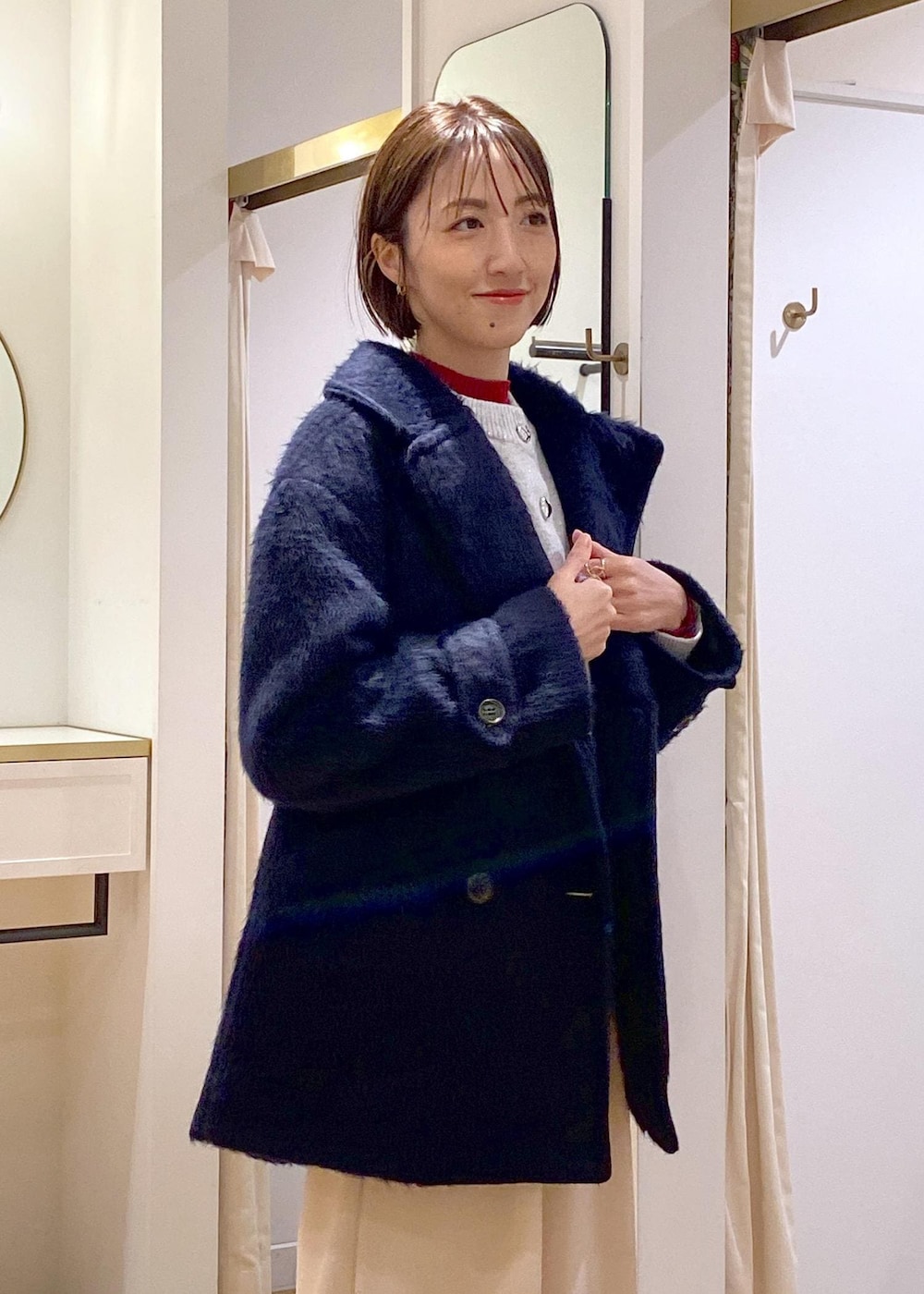 ホワイト系のブーツ、グレー系のカーディガン/ボレロ、レッド系のニット/セーターを着用したレディースの冬コーディネートの7枚目の写真