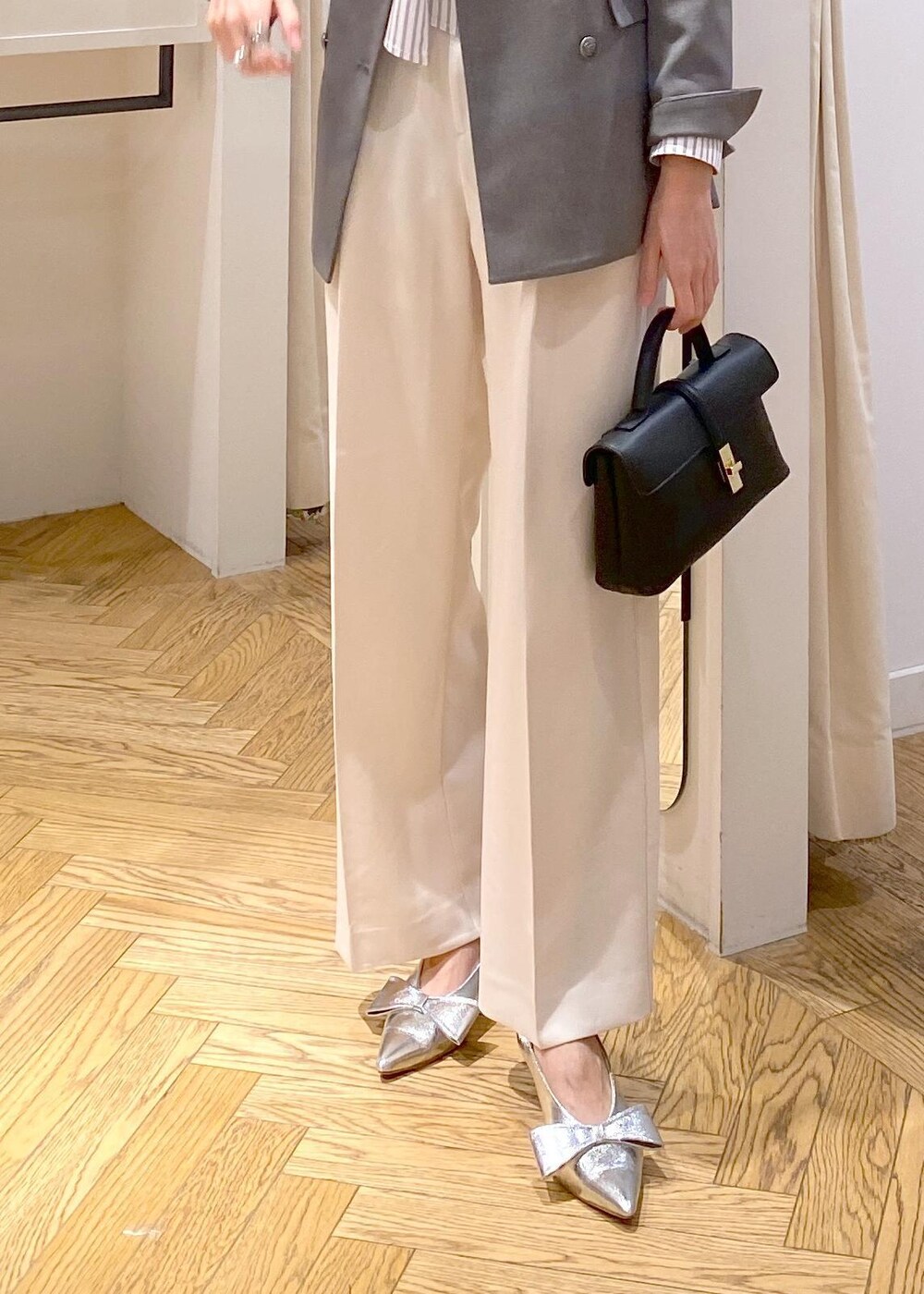 シルバー系のパンプス、ホワイト系のシャツ/ブラウス、ホワイト系のスラックスを着用したレディースの冬コーディネートの5枚目の写真