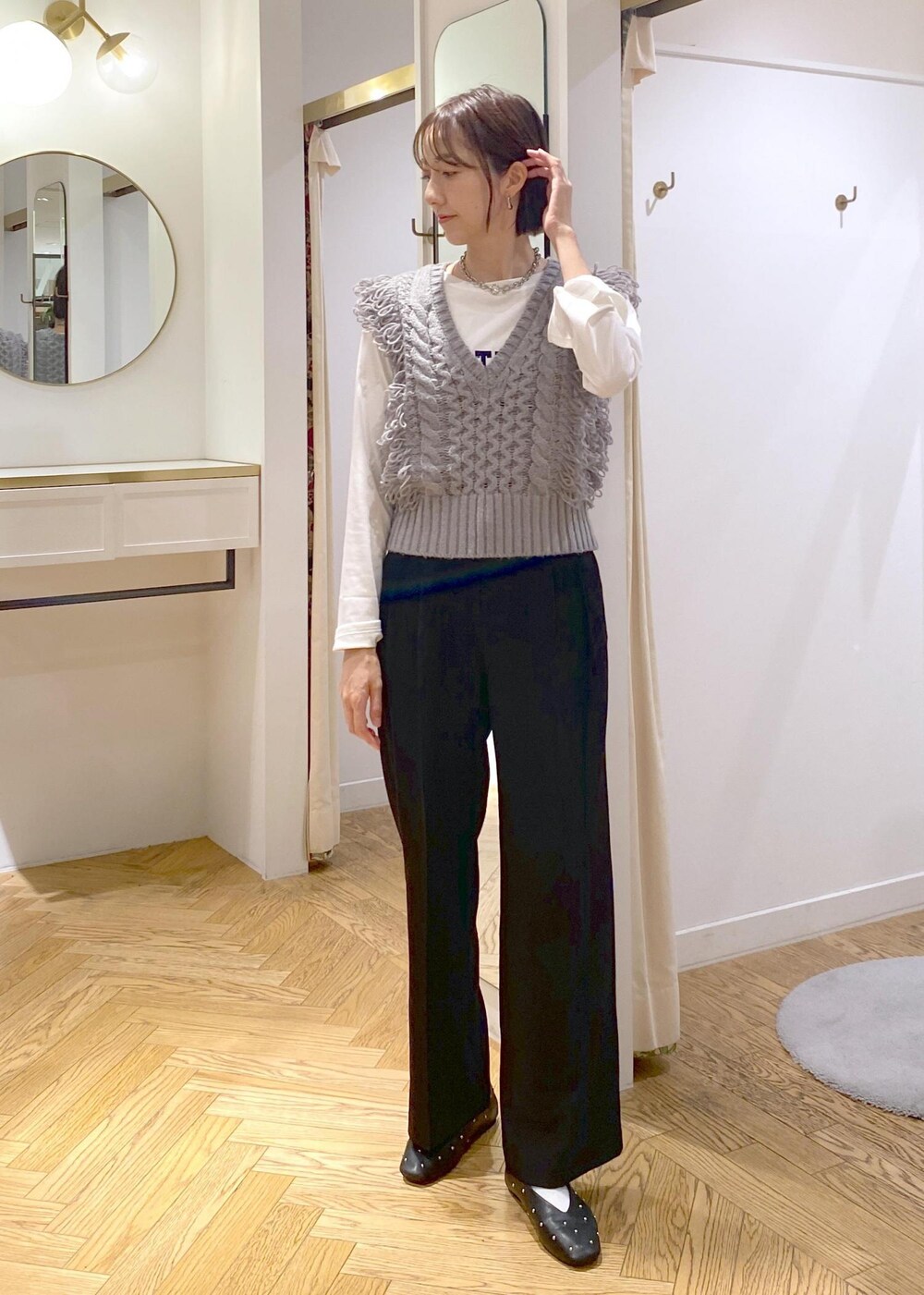 ブラック系のショルダーバッグ、ブラック系のバレエシューズ、ホワイト系のTシャツ/カットソーを着用したレディースの秋コーディネートの7枚目の写真