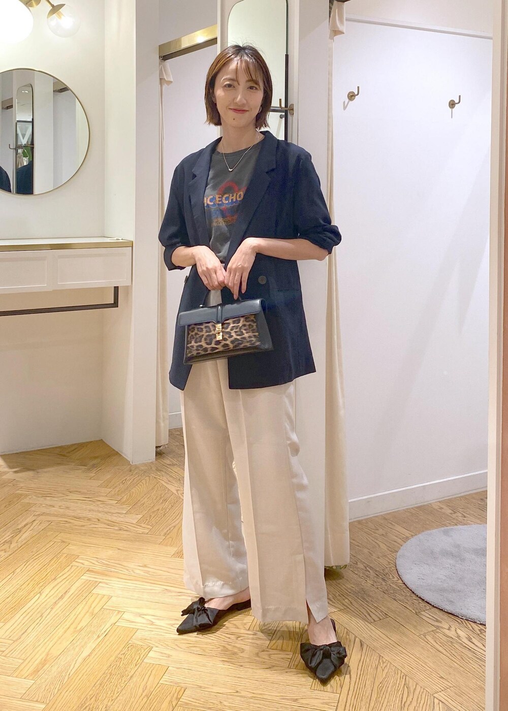 ブルー系のテーラードジャケット、ホワイト系のスラックス、その他のショルダーバッグを着用したレディースの夏コーディネートの4枚目の写真