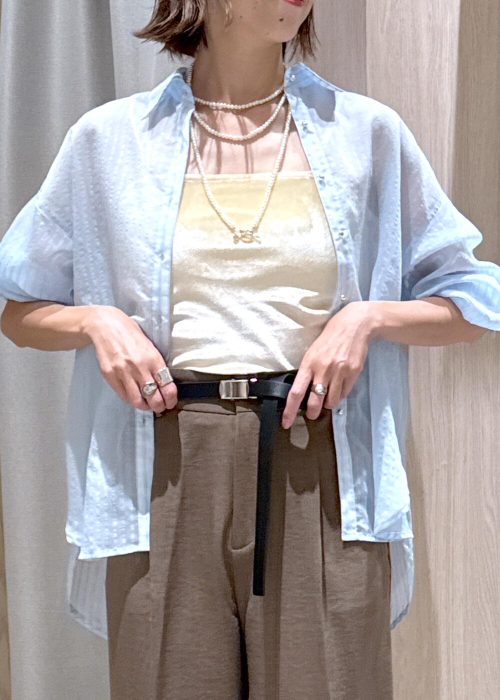 グリーン系のスラックス、ブラック系のパンプス、ベージュ系のボストンバッグを着用したレディースの秋コーディネートの9枚目の写真