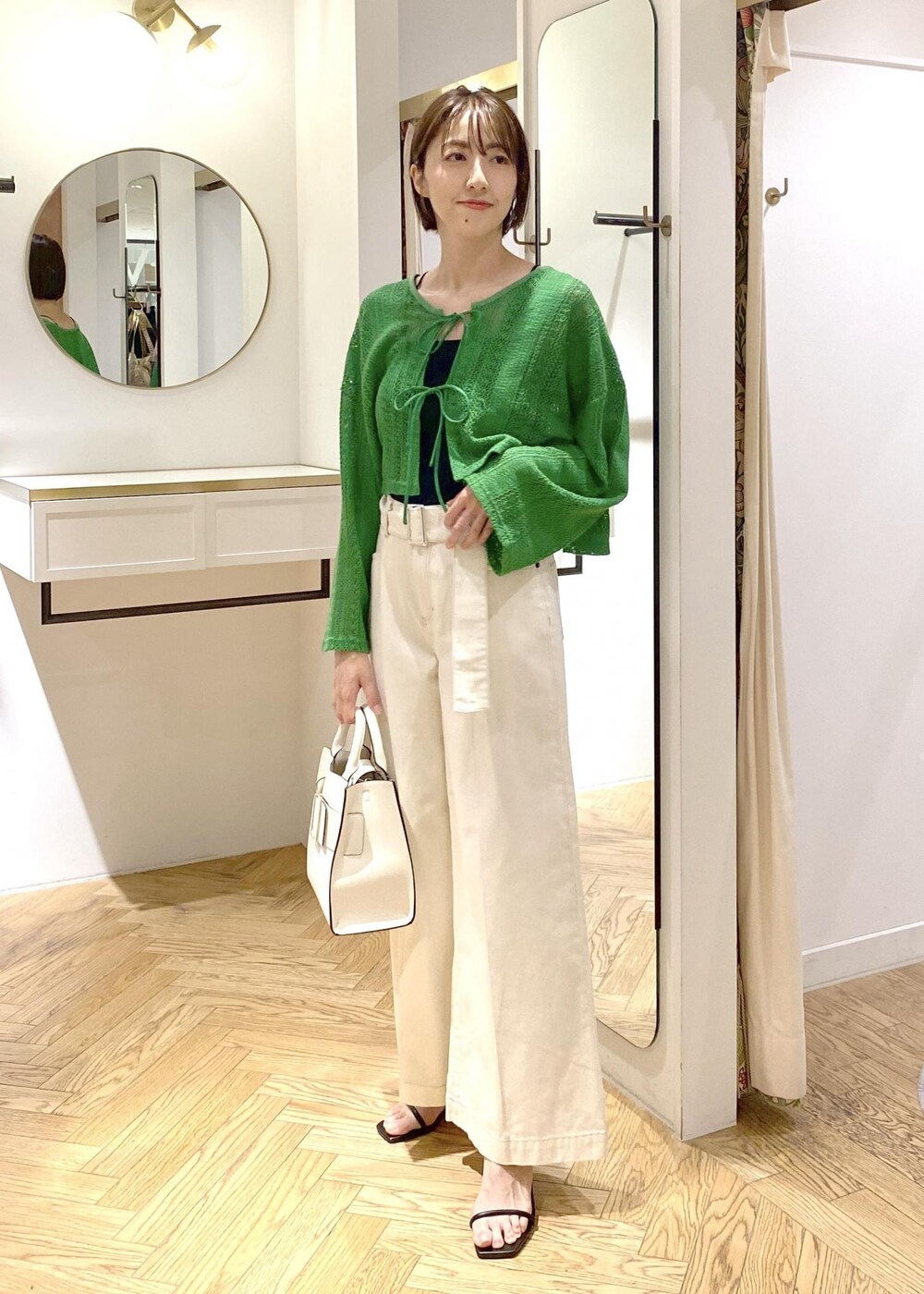 ブラック系のサンダル、ブラック系のキャミソール、ホワイト系のハンドバッグを着用したレディースの夏コーディネートの6枚目の写真