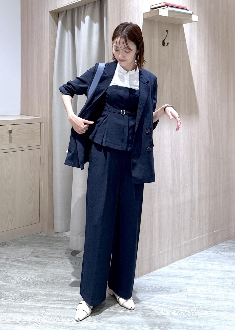 ベージュ系のトートバッグ、ホワイト系のパンプス、ブルー系のシャツ/ブラウスを着用したレディースの夏コーディネートの3枚目の写真