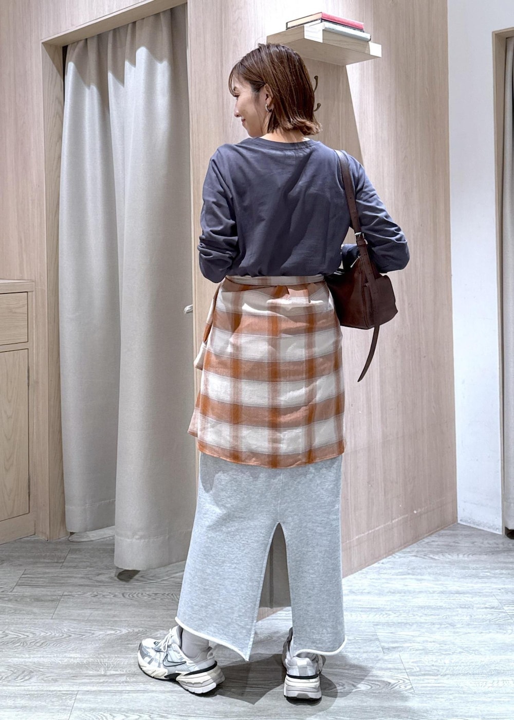 グレー系のスカート、ベージュ系のシャツ/ブラウス、グレー系のTシャツ/カットソーを着用したレディースの秋コーディネートの2枚目の写真