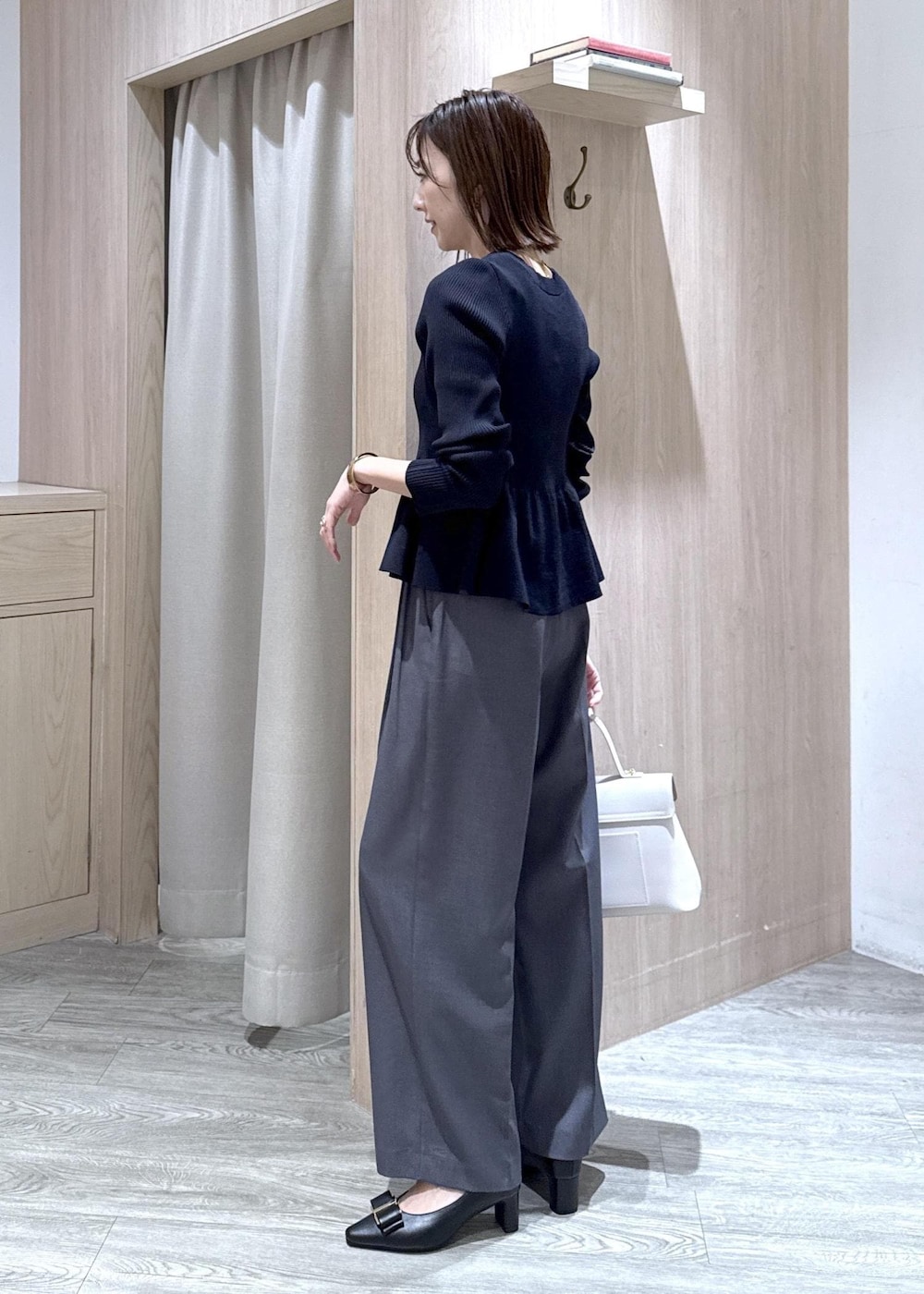 ブラック系のパンプス、グレー系のその他パンツ、ブルー系のカーディガン/ボレロを着用したレディースの冬コーディネートの9枚目の写真