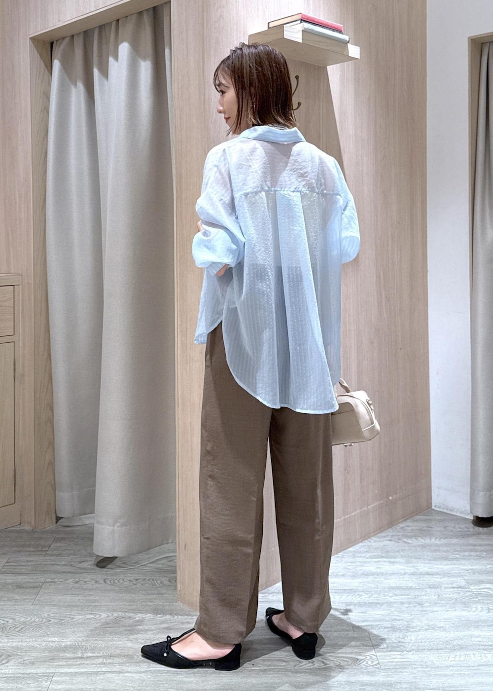 グリーン系のスラックス、ブラック系のパンプス、ベージュ系のボストンバッグを着用したレディースの秋コーディネートの4枚目の写真