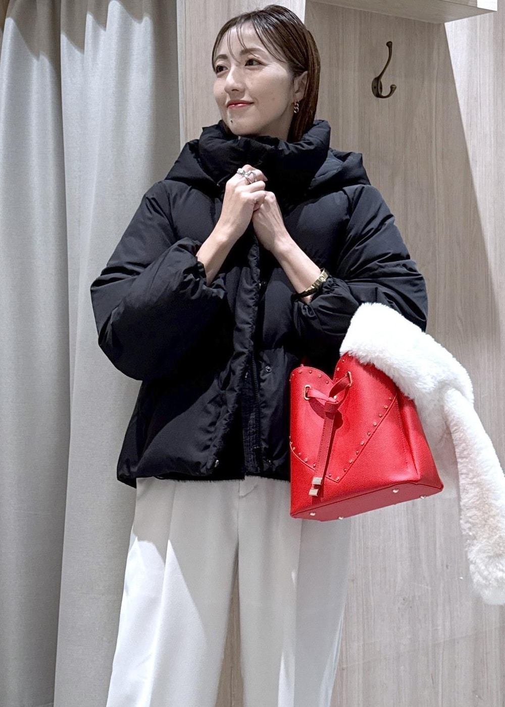 ブラック系のダウンジャケット/コート、ホワイト系のスラックス、ブラック系のニット/セーターを着用したレディースの冬コーディネートの4枚目の写真