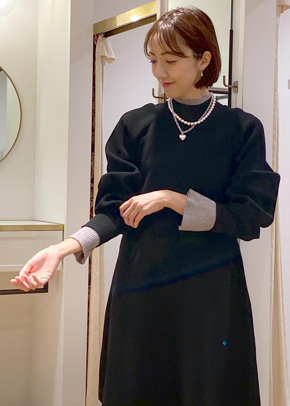 ブラック系のブーツ、ブラック系のワンピース、グレー系のニット/セーターを着用したレディースの秋コーディネートの6枚目の写真