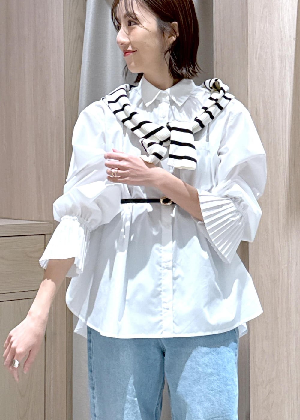 ブラック系のハンドバッグ、ブラック系のローファー、ホワイト系のシャツ/ブラウスを着用したレディースの春コーディネートの9枚目の写真