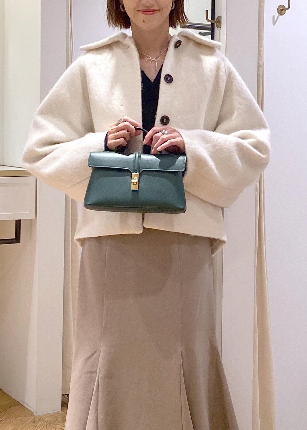 ホワイト系のブーツ、ベージュ系のスカート、ホワイト系のその他アウターを着用したレディースの秋コーディネートの5枚目の写真