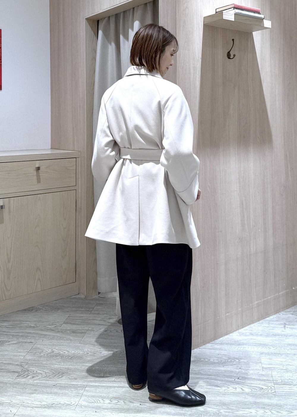 ブラック系のスラックス、ブラック系のショルダーバッグ、ブルー系のニット/セーターを着用したレディースの秋コーディネートの6枚目の写真