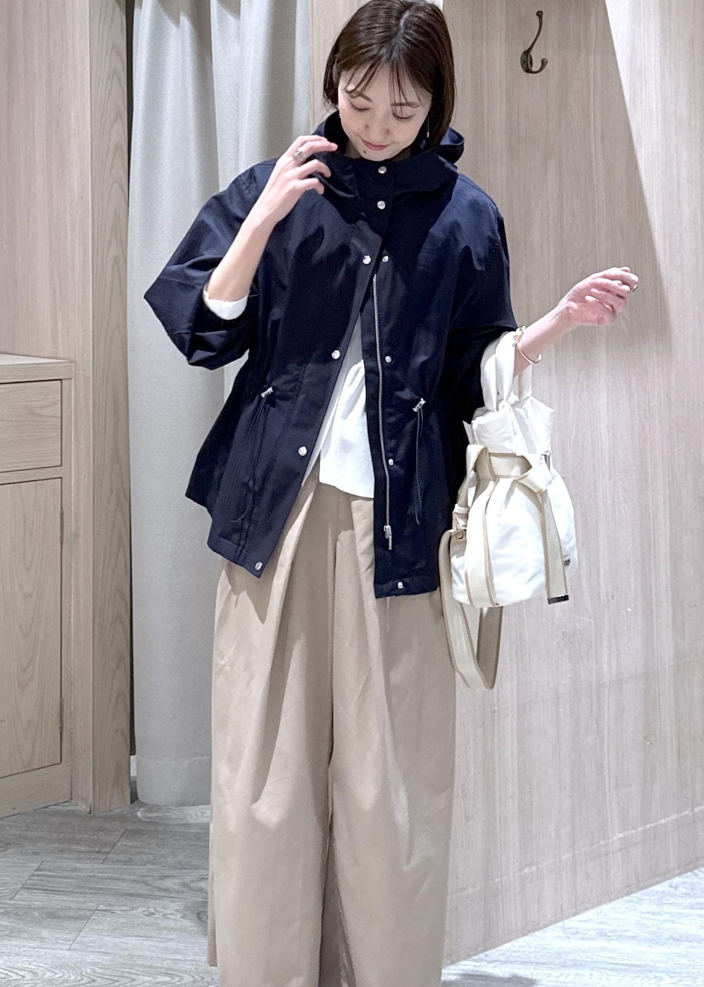 ホワイト系のカーディガン/ボレロ、ホワイト系のトートバッグ、ブルー系のナイロンジャケットを着用したレディースの春コーディネートの10枚目の写真