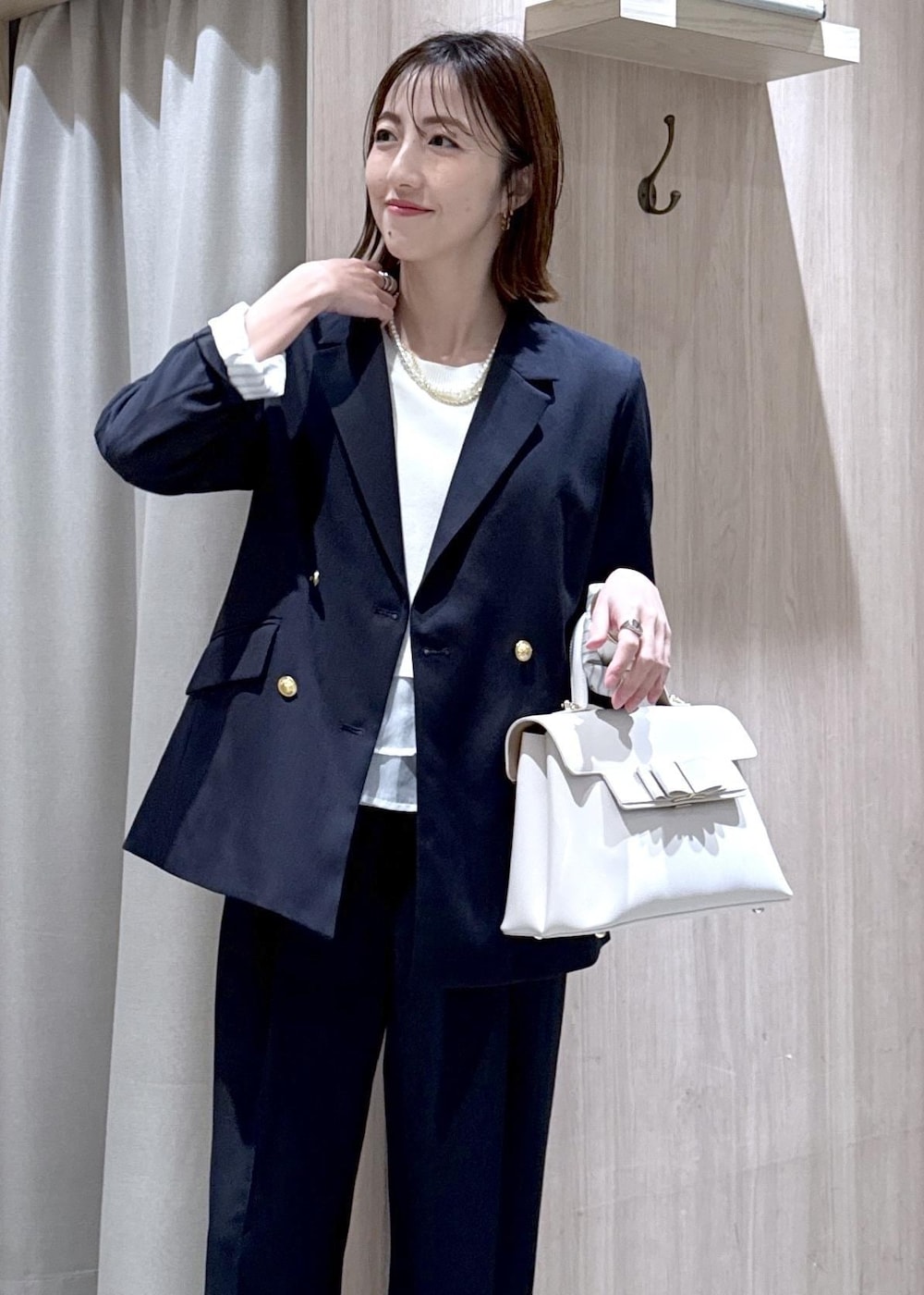 ブルー系のテーラードジャケット、ブルー系のその他パンツ、ホワイト系のハンドバッグを着用したレディースの冬コーディネートの10枚目の写真