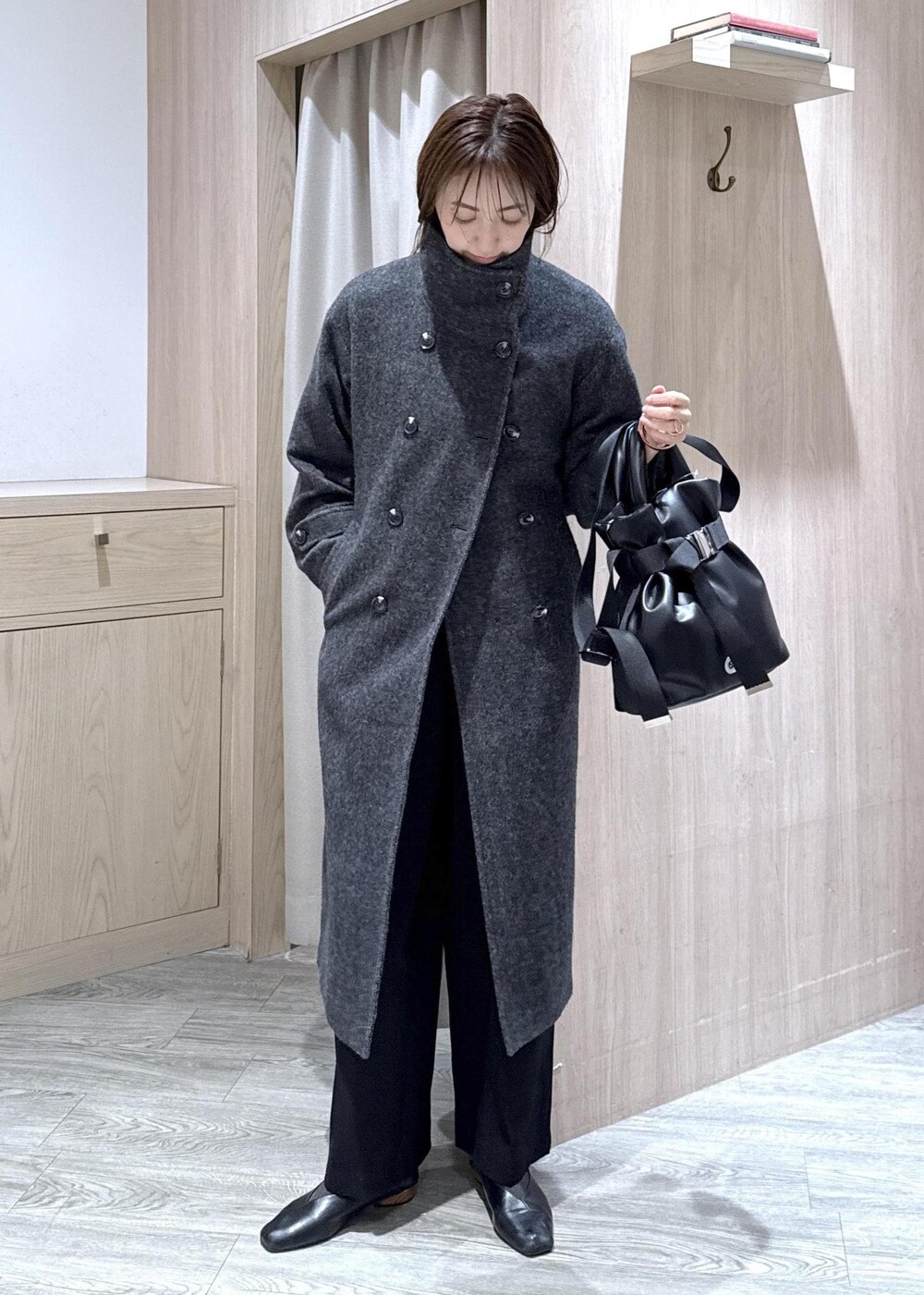 ブラック系のスラックス、グレー系のその他アウター、ブルー系のシャツ/ブラウスを着用したレディースの冬コーディネートの6枚目の写真