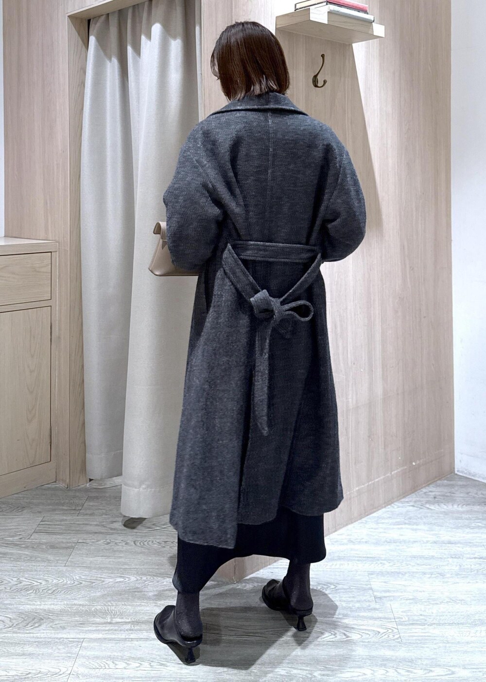 ベージュ系のショルダーバッグ、グレー系のその他アウター、ブラック系のスカートを着用したレディースの冬コーディネートの9枚目の写真