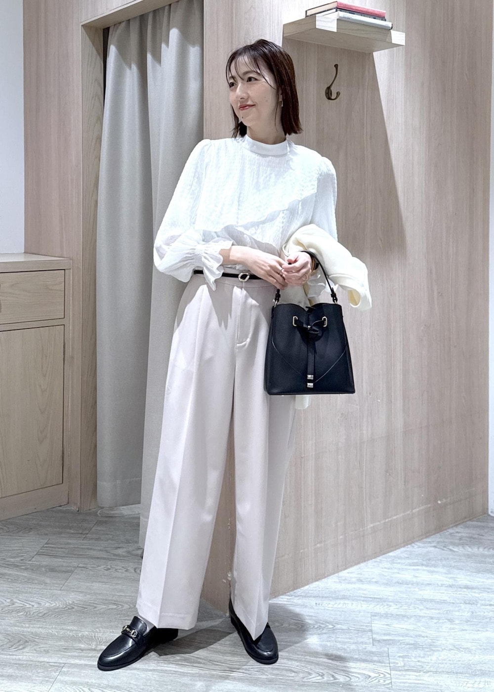 ブラック系のショルダーバッグ、ホワイト系のシャツ/ブラウス、ベージュ系のその他パンツを着用したレディースの冬コーディネートの9枚目の写真