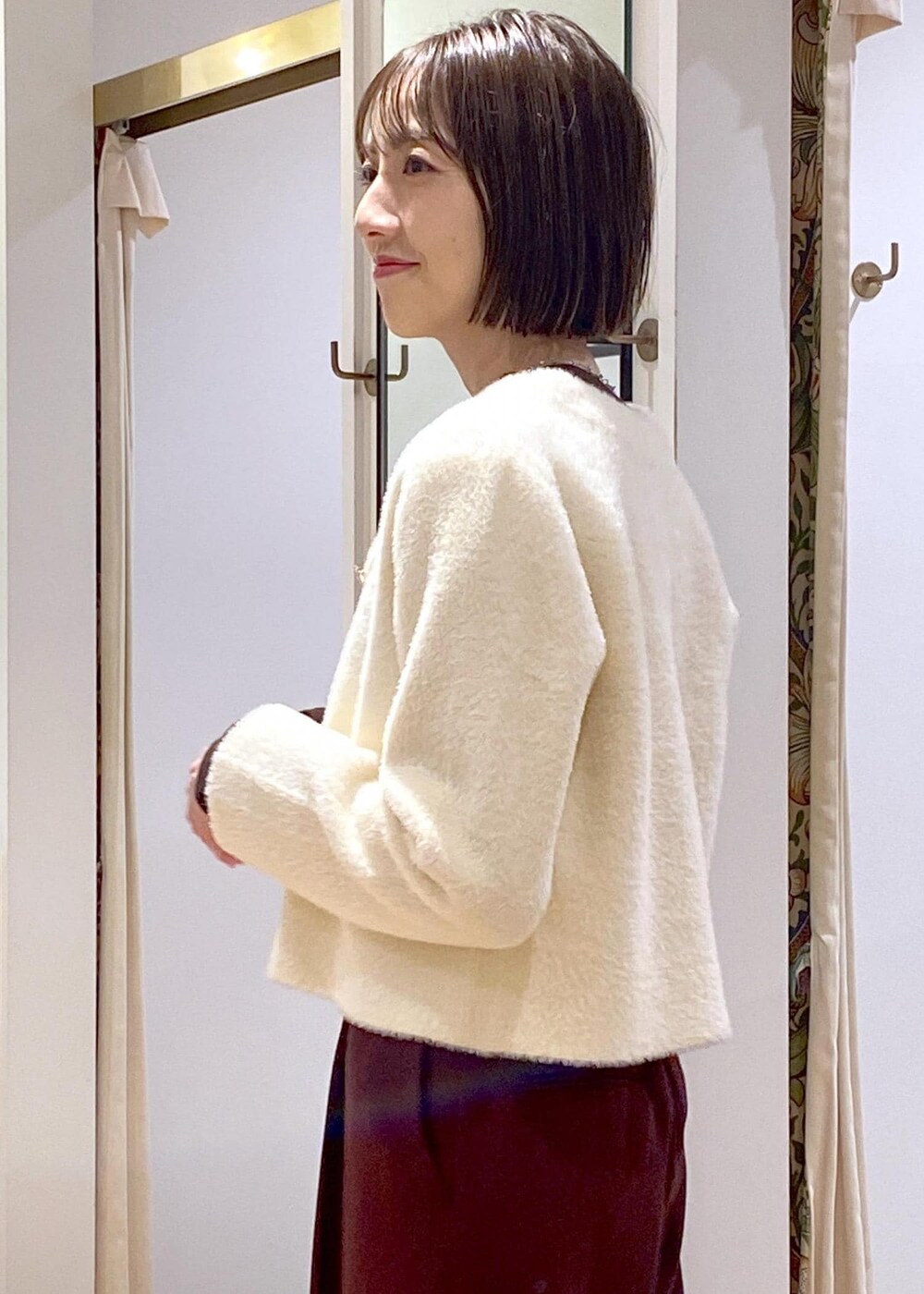 ホワイト系のハンドバッグ、ブラック系のパンプス、ブラウン系のその他パンツを着用したレディースの冬コーディネートの8枚目の写真