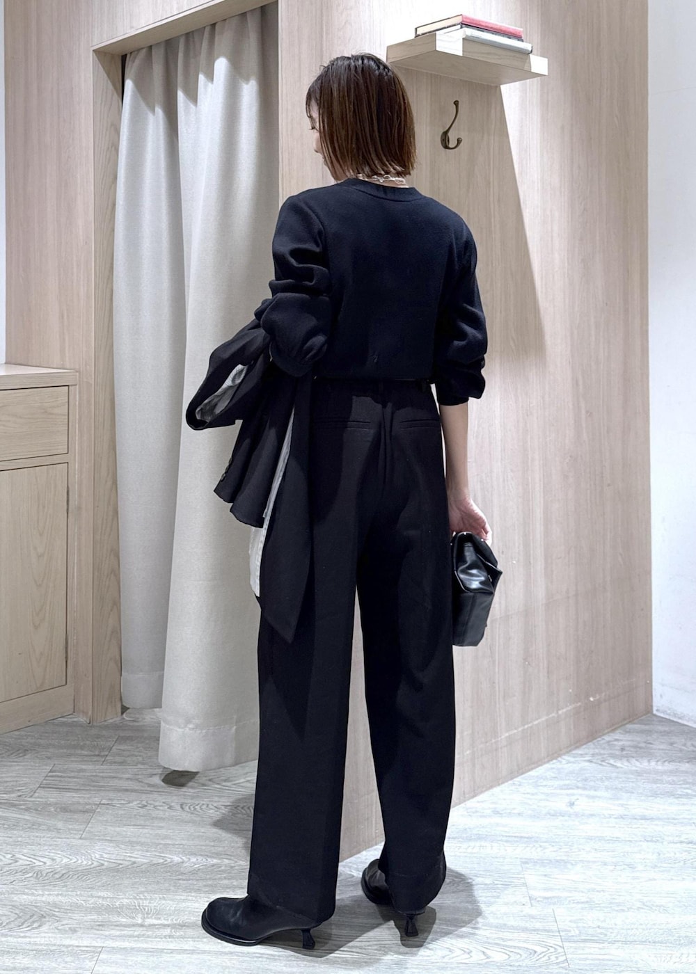 ブラック系のスラックス、ブラック系のテーラードジャケット、ブラック系のショルダーバッグを着用したレディースの冬コーディネートの7枚目の写真