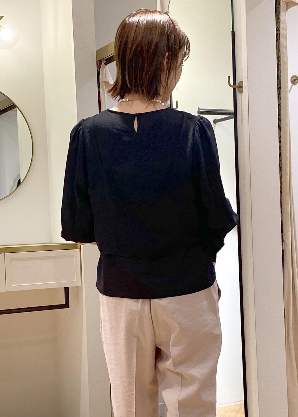 ブラック系のパンプス、ホワイト系のハンドバッグ、ブラック系のシャツ/ブラウスを着用したレディースの春コーディネートの3枚目の写真