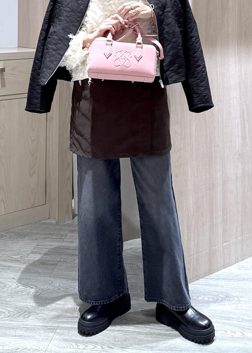 ピンク系のボストンバッグ、ブラック系のブーツ、ブラック系のブルゾンを着用したレディースの秋コーディネートの6枚目の写真