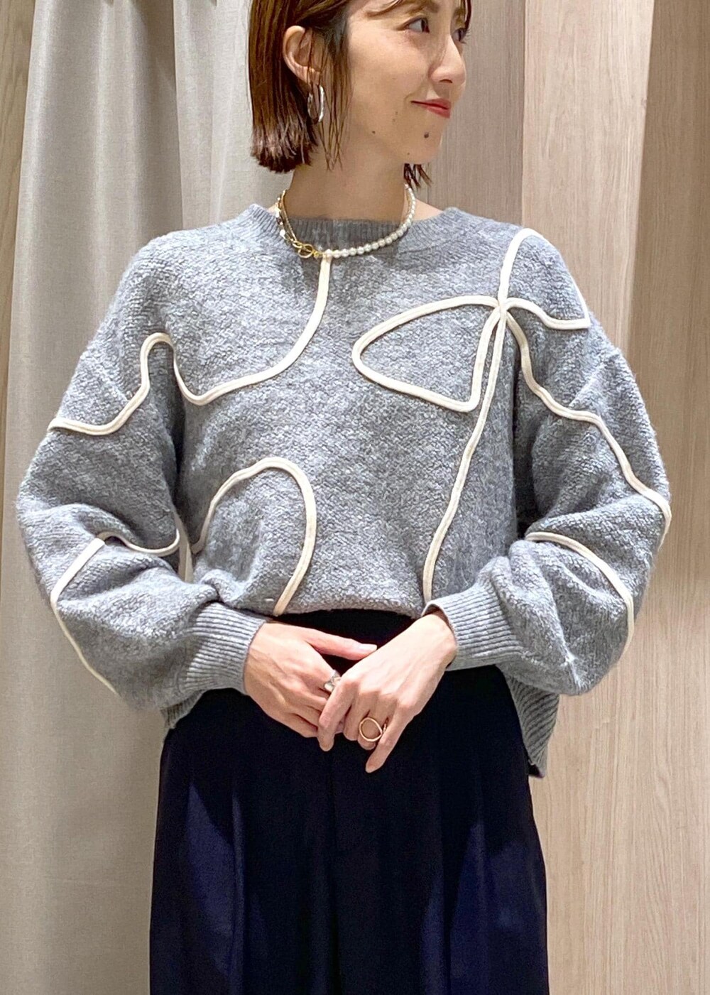 ブラック系のパンプス、グレー系のニット/セーター、ホワイト系のトートバッグを着用したレディースの冬コーディネートの8枚目の写真