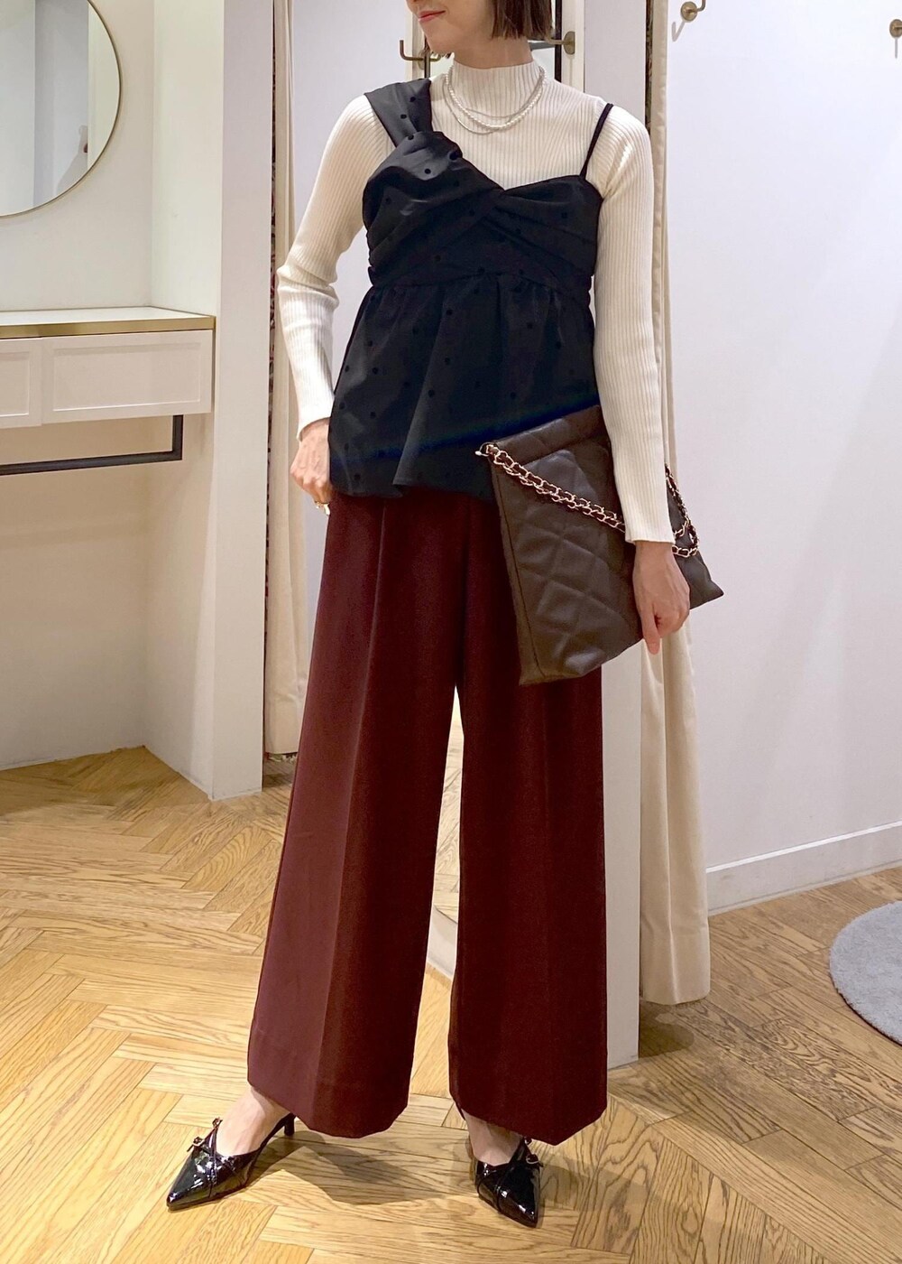 ブラック系のパンプス、ブラック系のキャミソール、ホワイト系のニット/セーターを着用したレディースの冬コーディネートの4枚目の写真