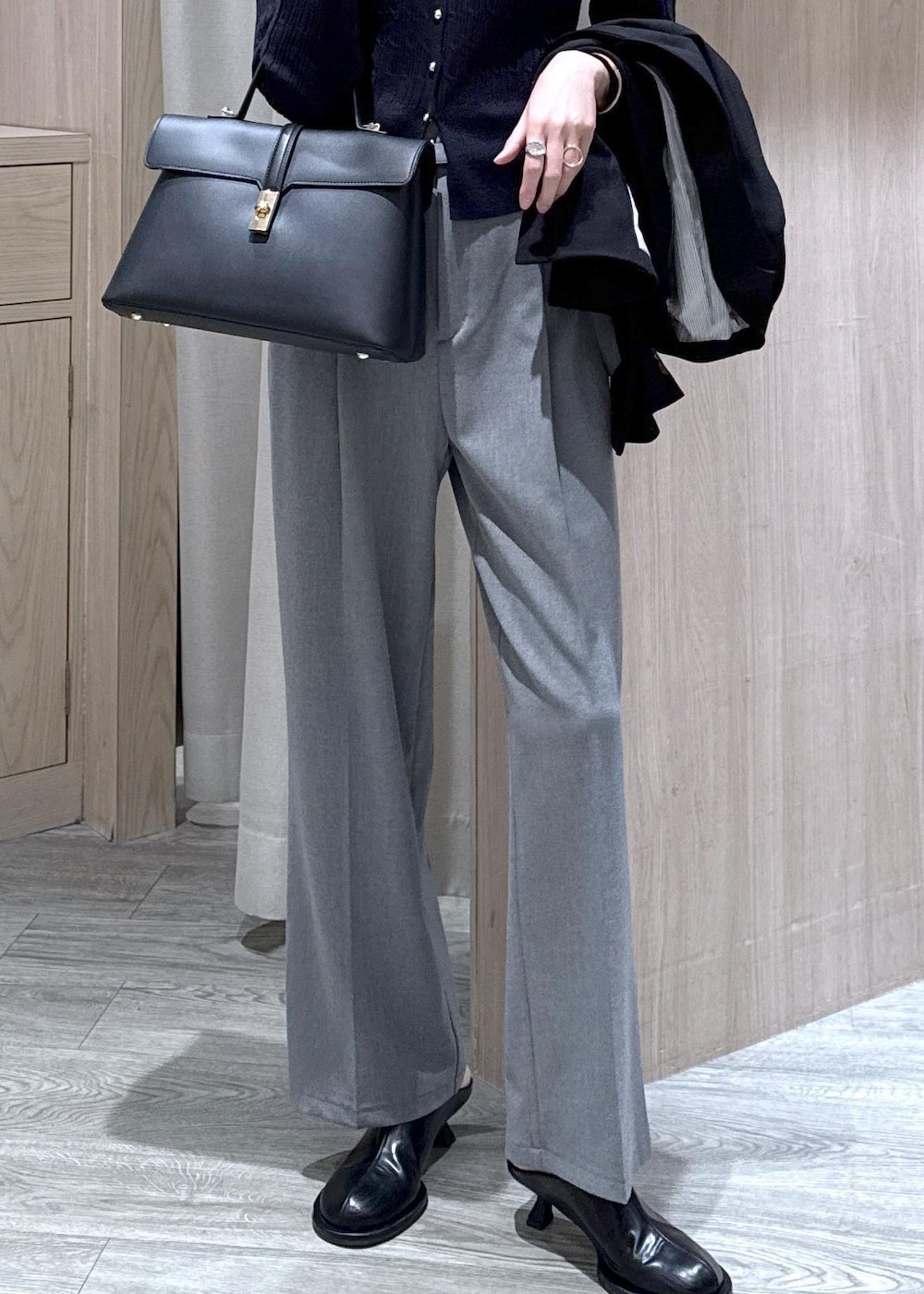 ブラック系のハンドバッグ、ブラック系のテーラードジャケット、グレー系のその他パンツを着用したレディースの冬コーディネートの3枚目の写真