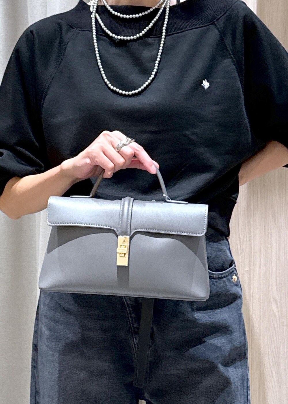 シルバー系のパンプス、ブラック系のキャミソール、グレー系のショルダーバッグを着用したレディースの秋コーディネートの7枚目の写真