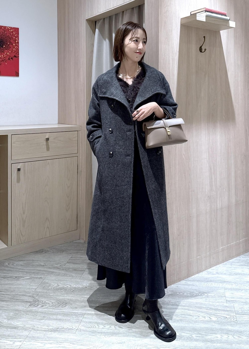 ベージュ系のショルダーバッグ、グレー系のその他アウター、ブラック系のスカートを着用したレディースの冬コーディネートの8枚目の写真