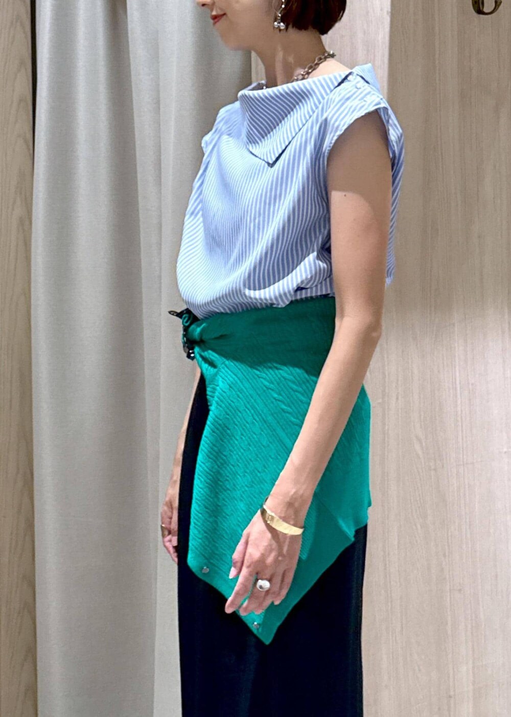 シルバー系のパンプス、ブラック系のハンドバッグ、ブルー系のスラックスを着用したレディースの夏コーディネートの7枚目の写真