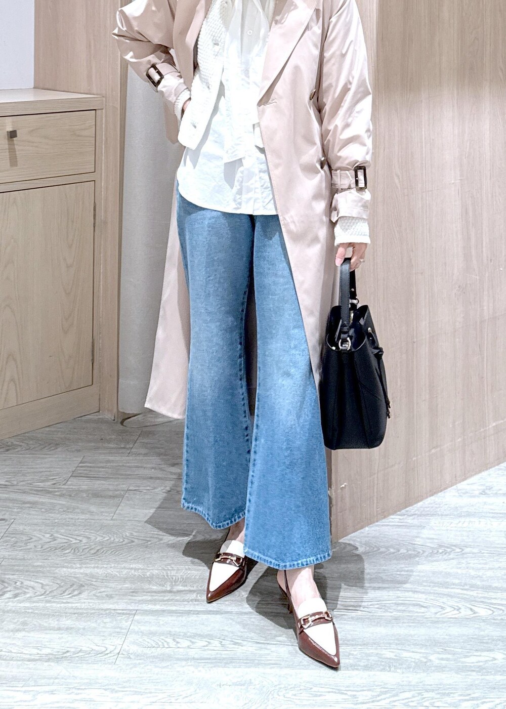 ブラック系のショルダーバッグ、ベージュ系のトレンチコート、ホワイト系のカーディガン/ボレロを着用したレディースの春コーディネートの3枚目の写真