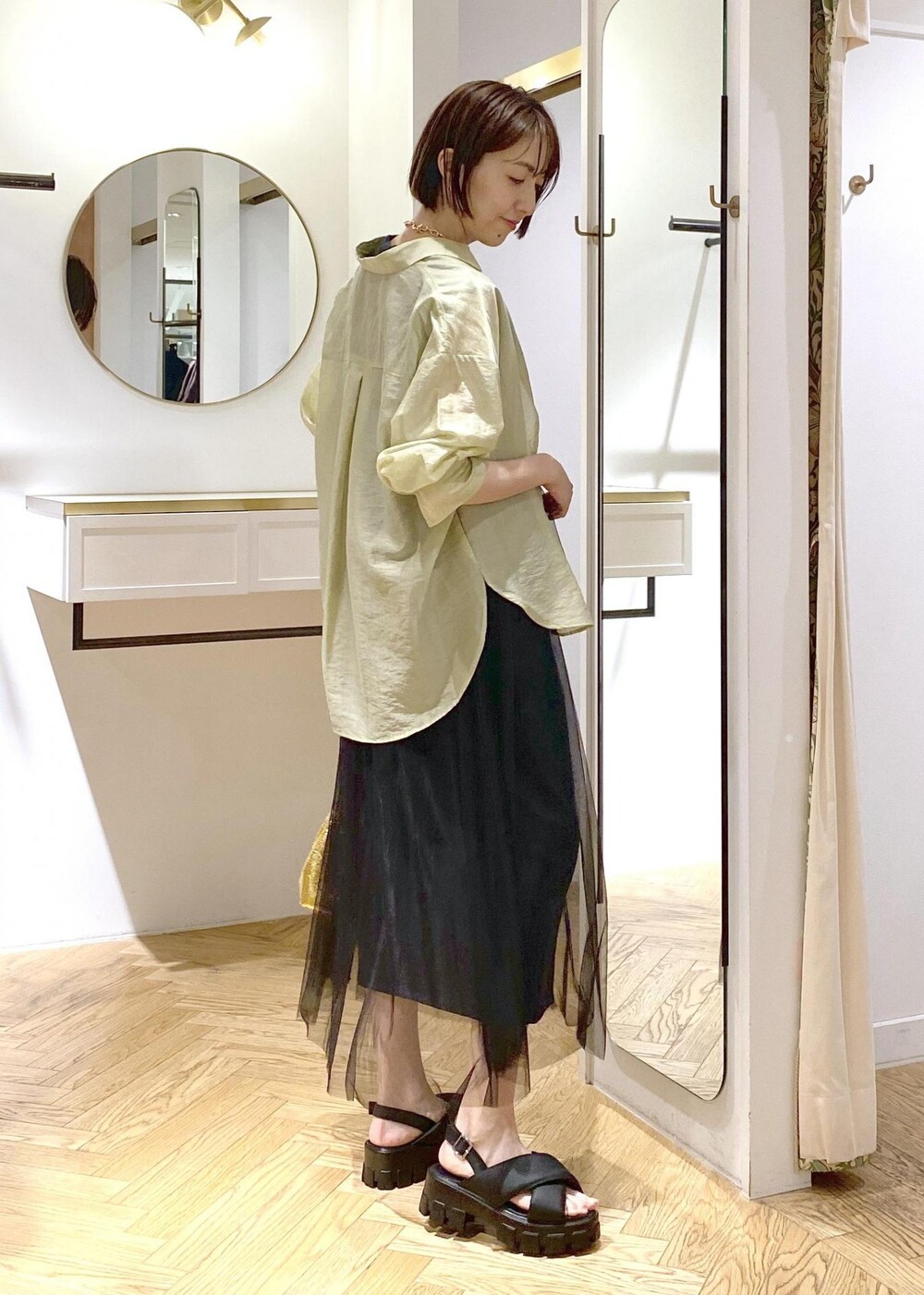 グリーン系のシャツ/ブラウス、ブラック系のサンダル、ブラック系のワンピースを着用したレディースの夏コーディネートの2枚目の写真