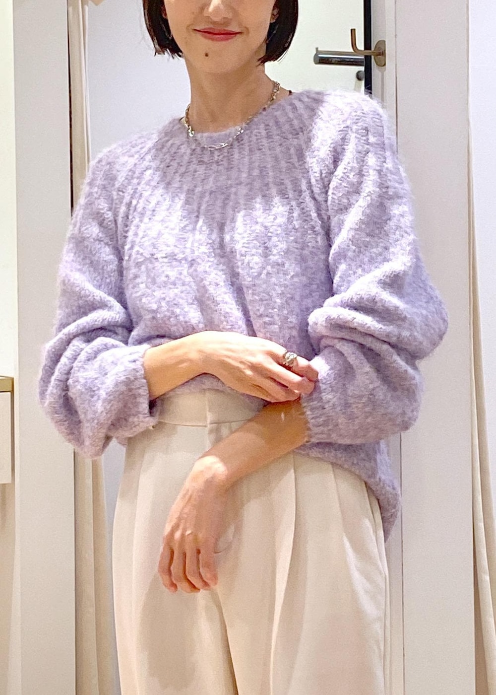 ホワイト系のブーツ、ブラック系のショルダーバッグ、パープル系のニット/セーターを着用したレディースの冬コーディネートの8枚目の写真