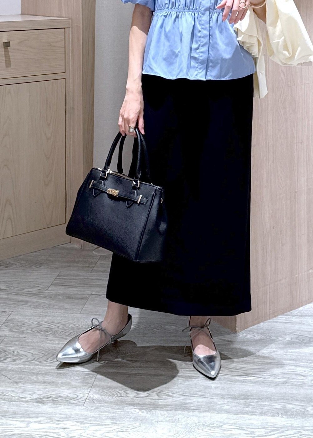 ホワイト系のカーディガン/ボレロ、ブラック系のショルダーバッグ、シルバー系のパンプスを着用したレディースの春コーディネートの6枚目の写真