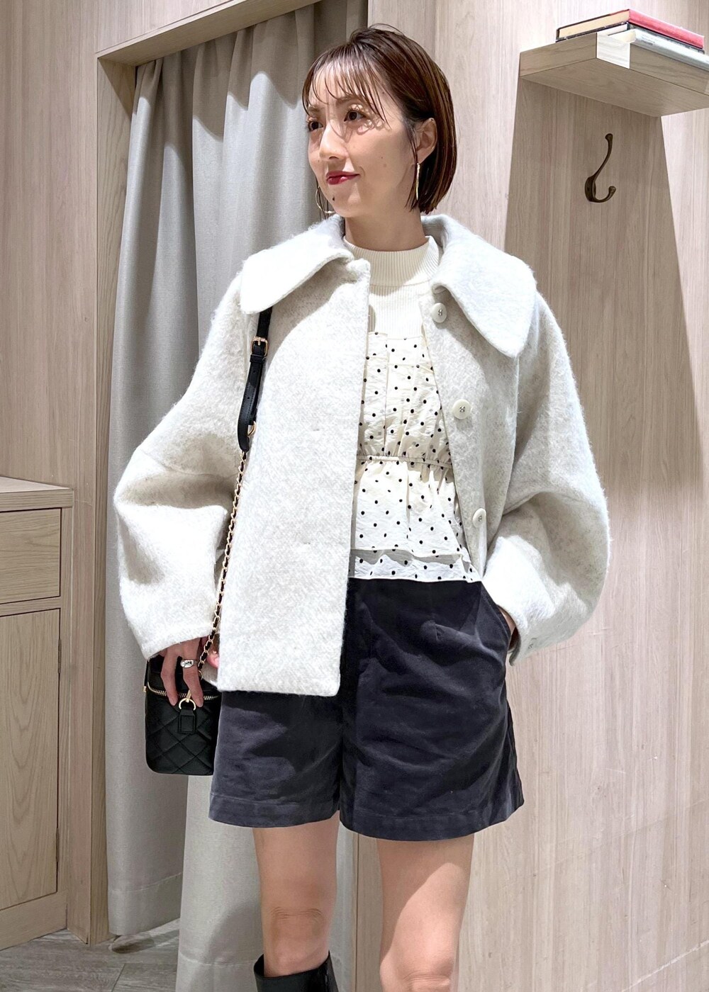 ブラック系のブーツ、ホワイト系のブルゾン、ホワイト系のニット/セーターを着用したレディースの秋コーディネートの8枚目の写真