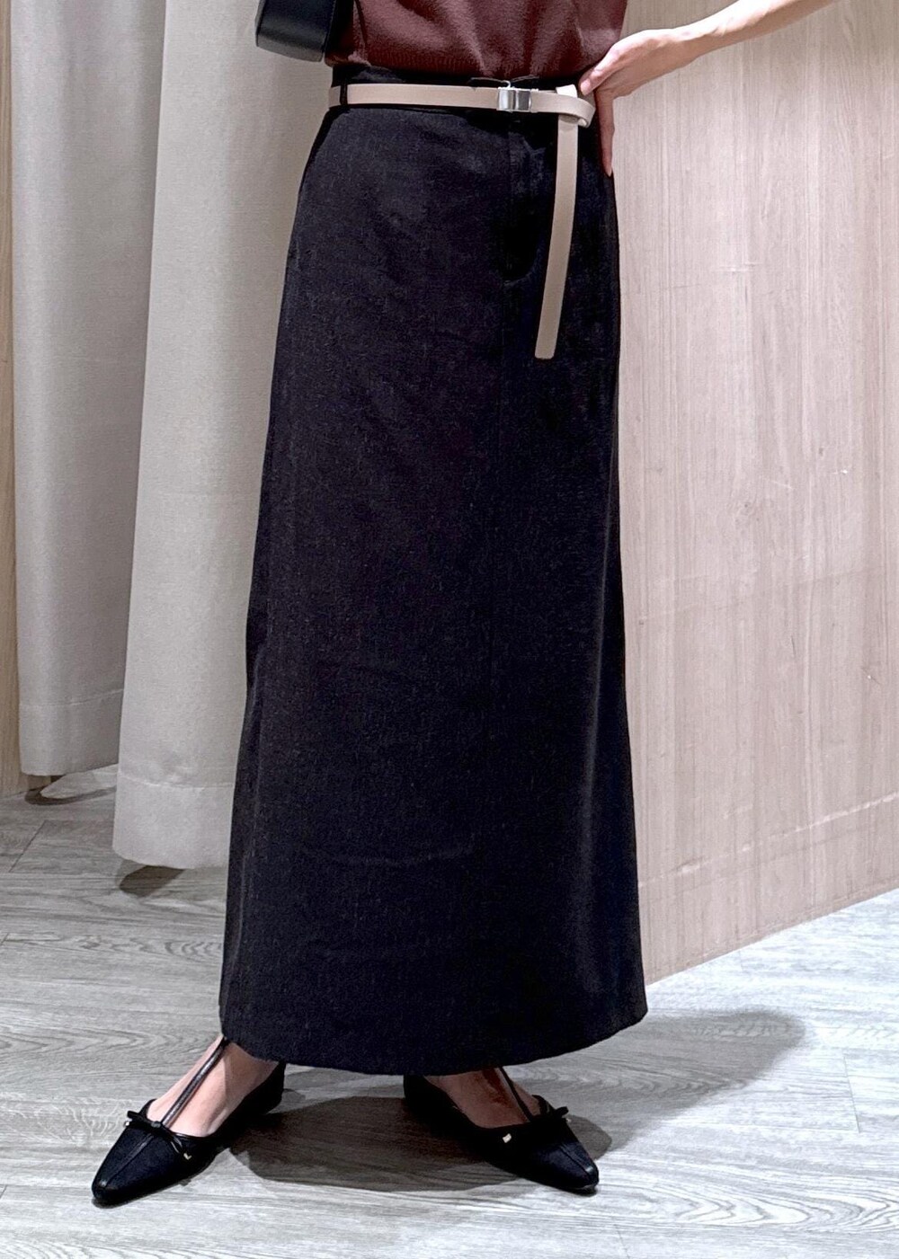 ブラック系のハンドバッグ、グレー系のスカート、ブラック系のパンプスを着用したレディースの夏コーディネートの6枚目の写真