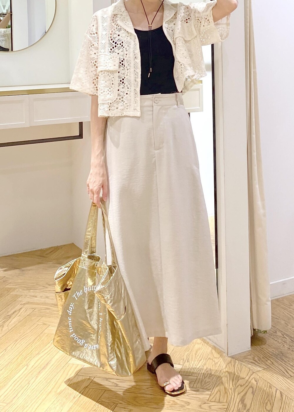 ブラック系のキャミソール、ブラック系のサンダル、ゴールド系のトートバッグを着用したレディースの春コーディネートの5枚目の写真