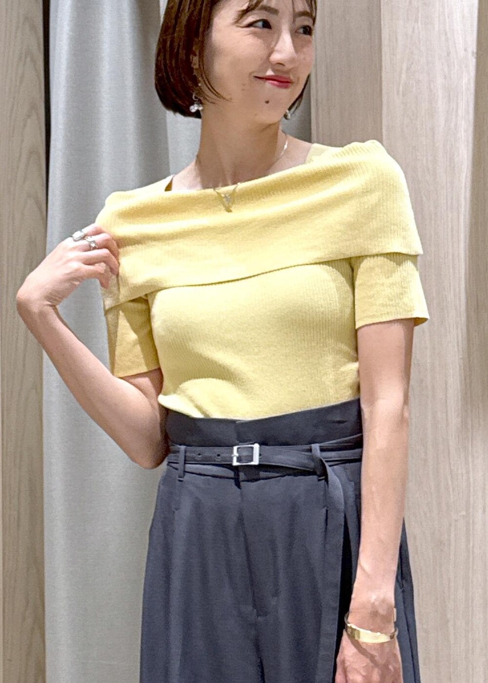 ブラック系のショルダーバッグ、ブラック系のバレエシューズ、イエロー系のニット/セーターを着用したレディースの夏コーディネートの7枚目の写真