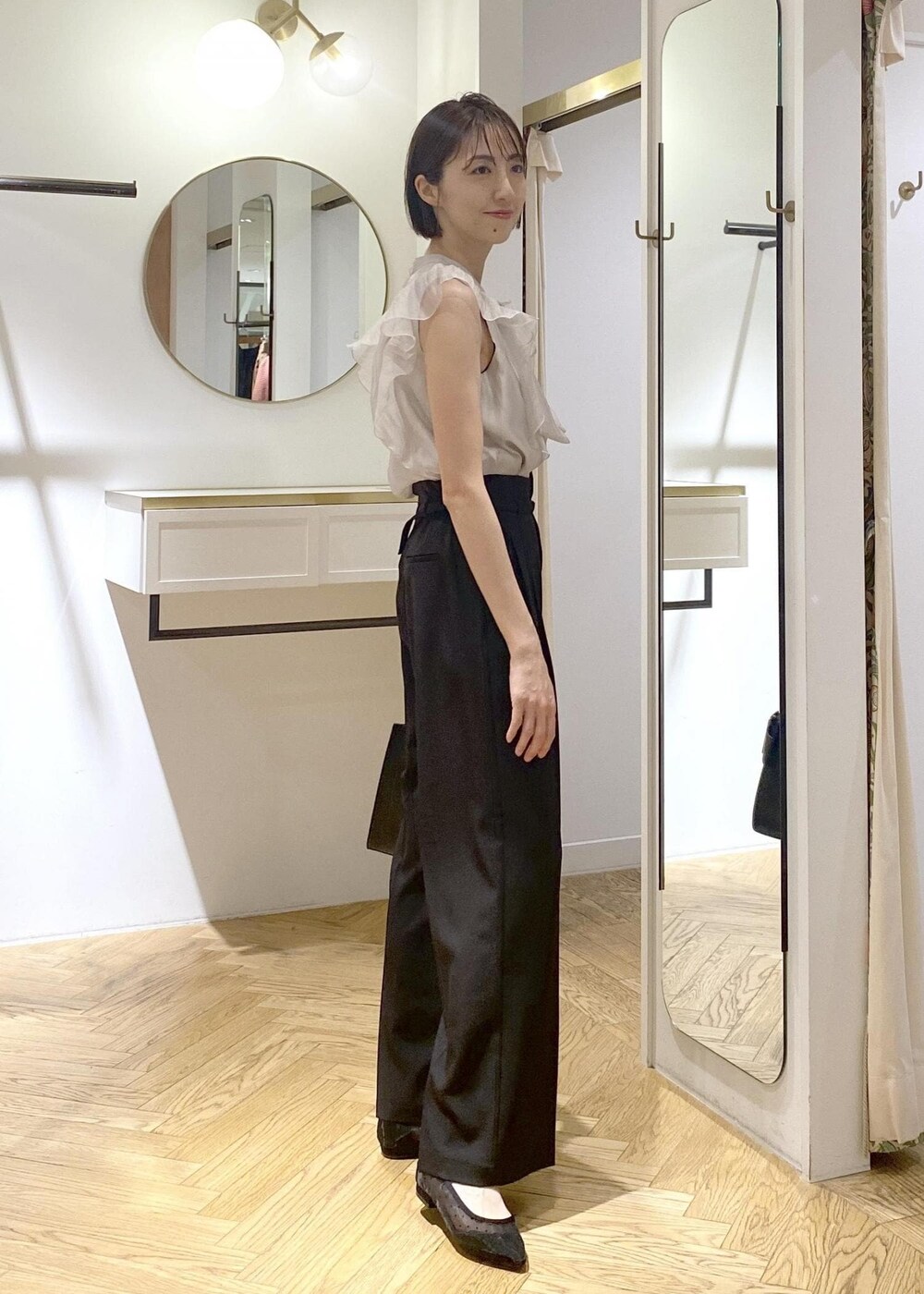 ブラック系のキャミソール、ブラック系のパンプス、ブラック系のハンドバッグを着用したレディースの夏コーディネートの2枚目の写真