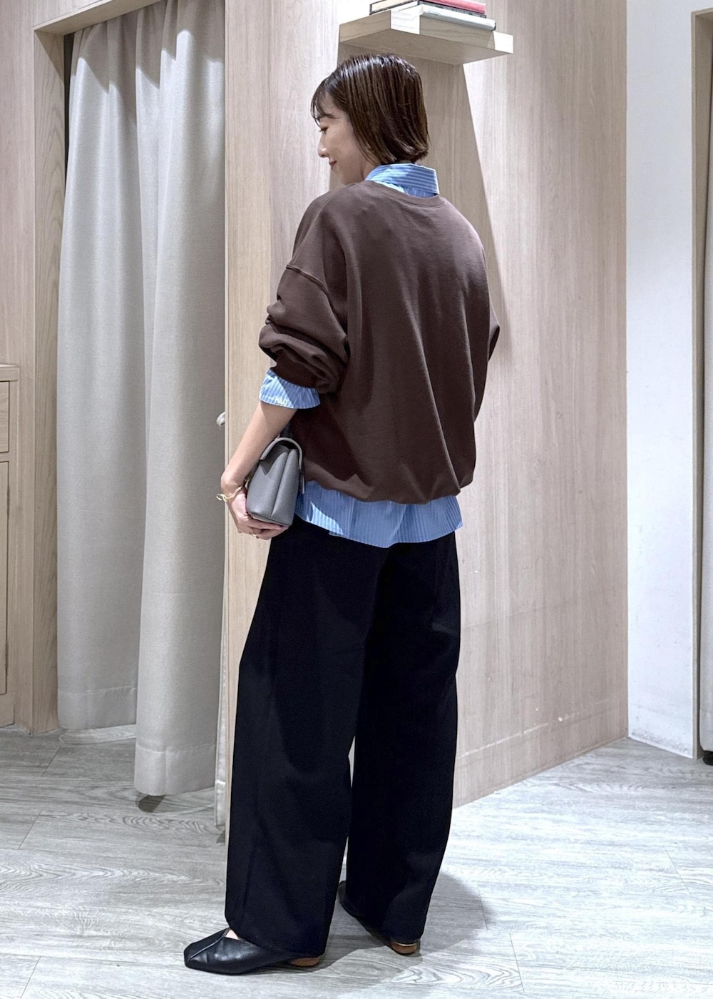グレー系のショルダーバッグ、ブラック系のスラックス、ブルー系のシャツ/ブラウスを着用したレディースの秋コーディネートの2枚目の写真