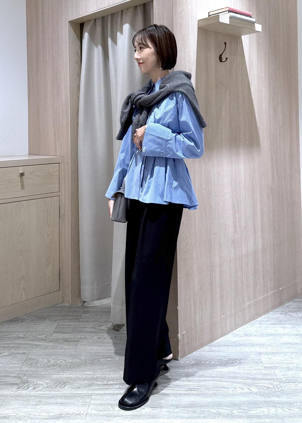 グレー系のショルダーバッグ、ブラック系のスラックス、グレー系のカーディガン/ボレロを着用したレディースの秋コーディネートの4枚目の写真