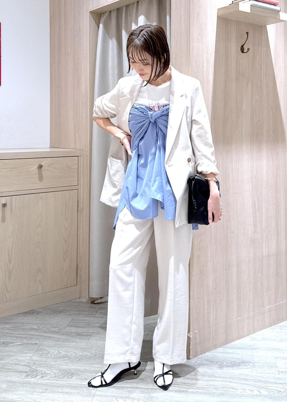 ブルー系のシャツ/ブラウス、ブラック系のサンダル、ホワイト系のTシャツ/カットソーを着用したレディースの春コーディネートの4枚目の写真