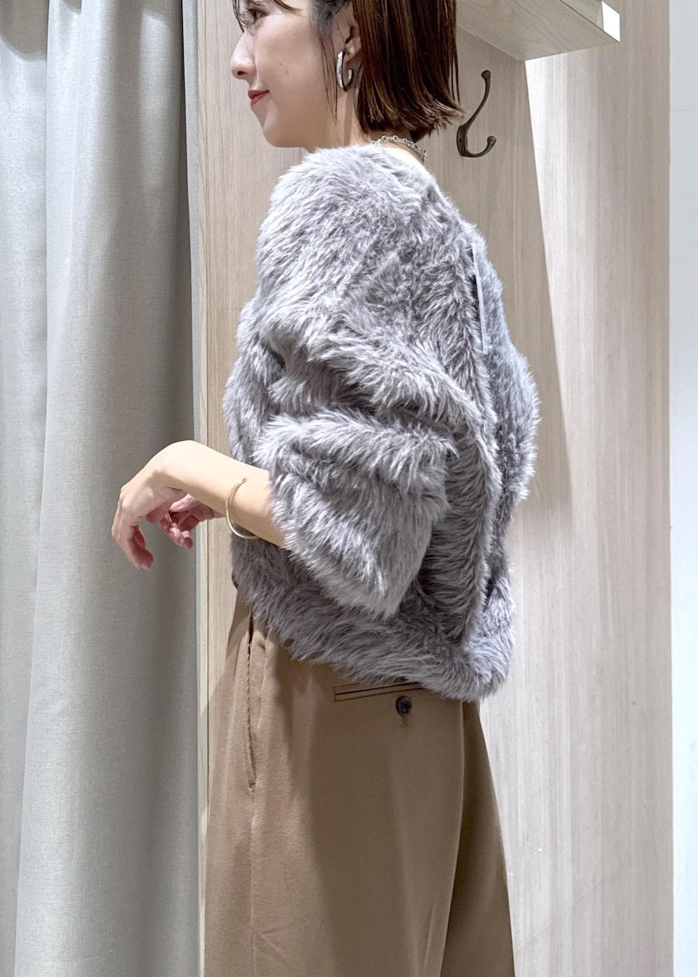 ブラック系のショルダーバッグ、グレー系のカーディガン/ボレロ、ブラック系のブーツを着用したレディースの秋コーディネートの9枚目の写真