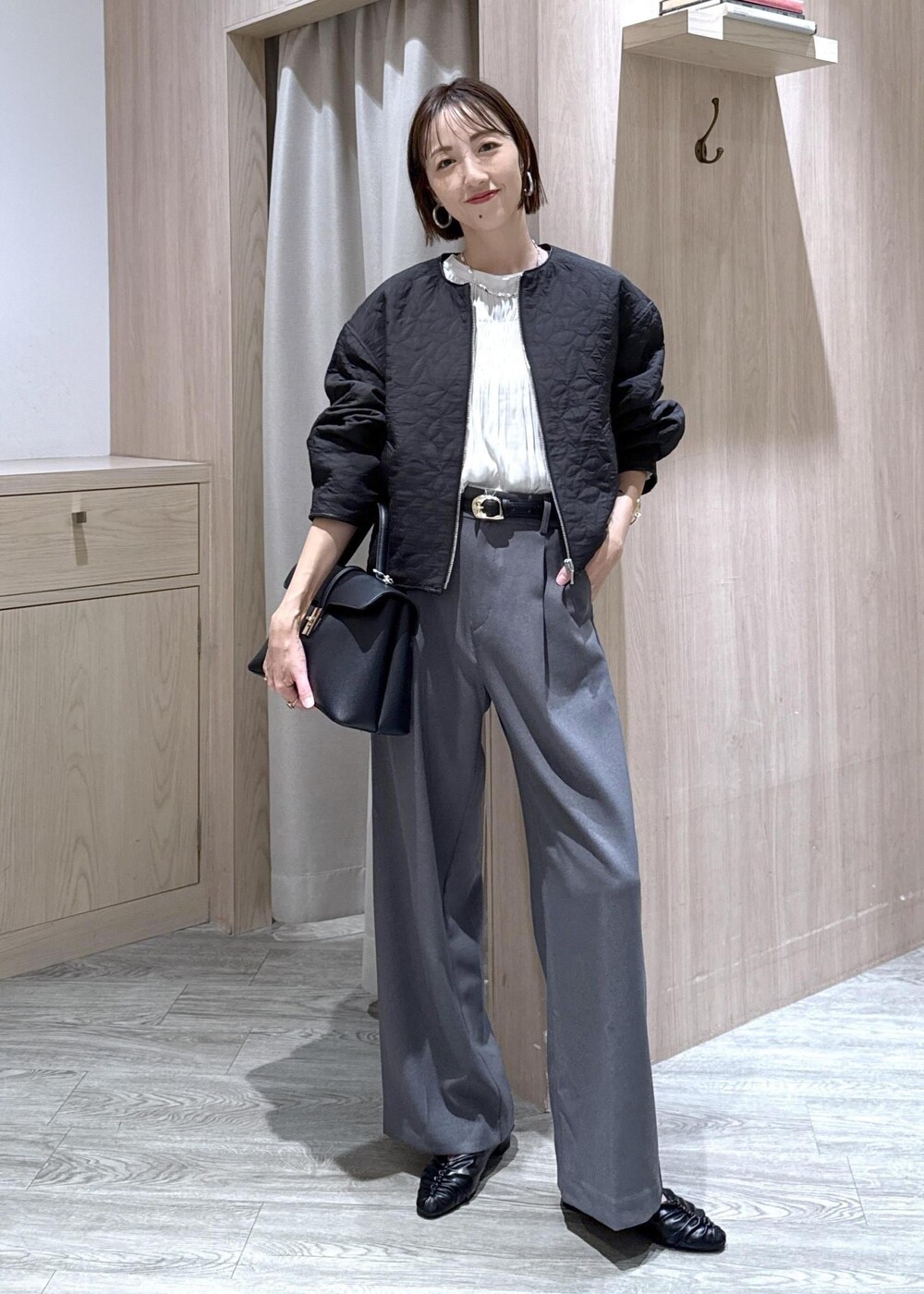 ブラック系のハンドバッグ、グレー系のスラックス、ホワイト系のシャツ/ブラウスを着用したレディースの秋コーディネートの5枚目の写真