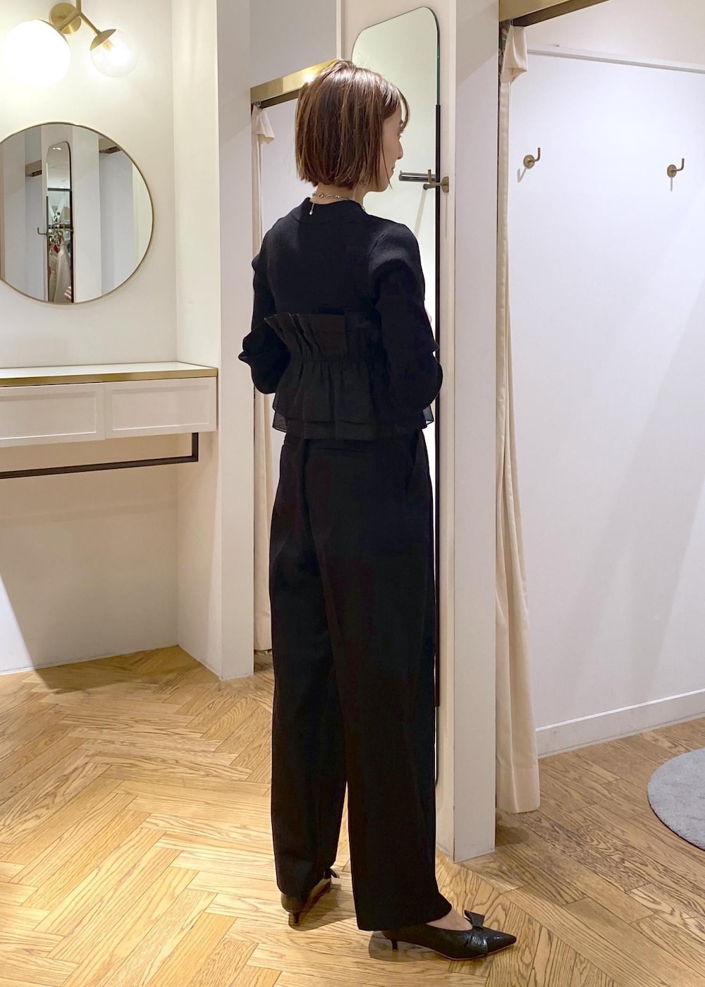 ブラック系のパンプス、ブラック系のニット/セーター、ブラック系のスラックスを着用したレディースの冬コーディネートの10枚目の写真