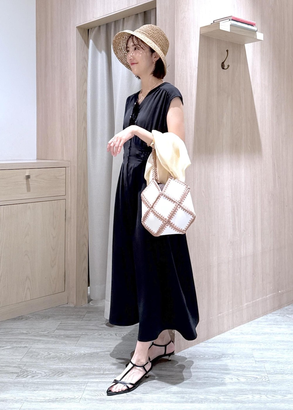 ブラック系のサンダル、ホワイト系のハンドバッグ、ホワイト系のカーディガン/ボレロを着用したレディースの春コーディネートの3枚目の写真