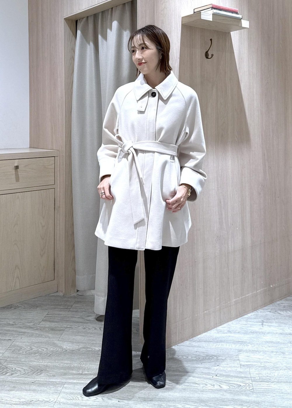 ブラック系のスラックス、ブラック系のショルダーバッグ、ブルー系のニット/セーターを着用したレディースの秋コーディネートの5枚目の写真